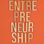 Wooden letters on orange background spelling 'ENTREPRENEURSHIP', symbolizing business aspirations.